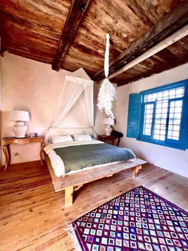 a bedroom with a bed and a wooden ceiling at Beit Dina in Siwa