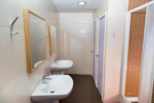 Alberg Sants Bcn في برشلونة: حمام أبيض مع حوض ومرآة