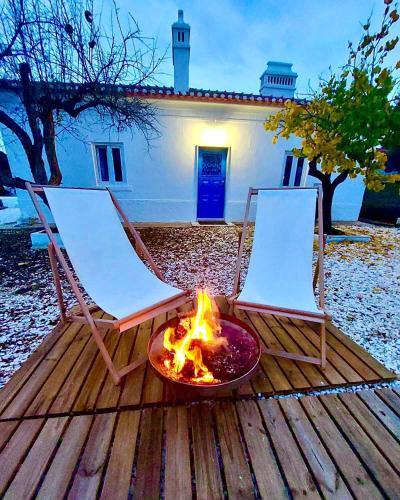 two chairs and a fire pit on a deck at Mileu slowhouse in Veiros