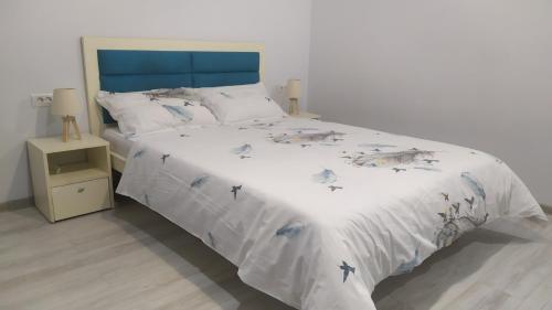 a bed with a blue headboard and birds on it at Ami Studio in Constanţa
