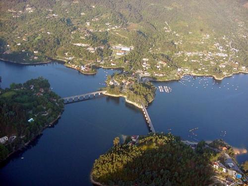an island with a bridge in a large body of water at Quinta Flor de Lis, Gerês in Vieira do Minho