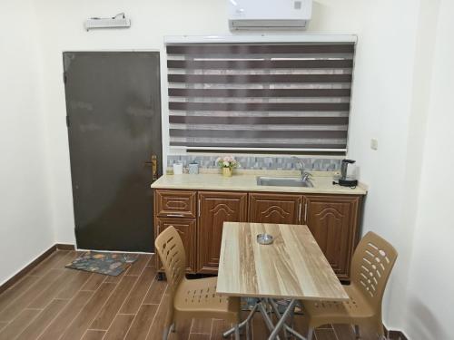 a kitchen with a wooden table and a sink at EMILE ALTWAL in Madaba