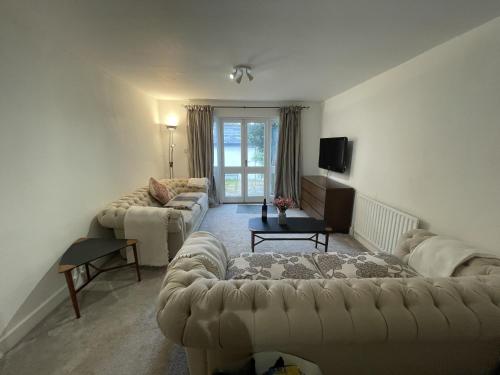 un salon avec deux canapés et une télévision dans l'établissement Poplar Cottage Farnborough Kent, à Orpington