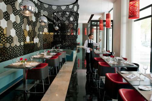 a man standing in a dining room with tables at Barceló Fès Medina in Fez