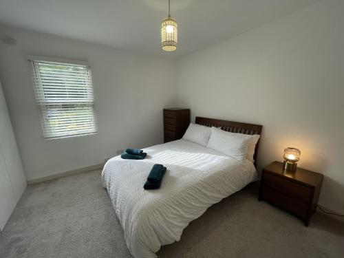 a bedroom with a white bed with a nightstand and a bed sidx sidx sidx at Poplar Cottage Farnborough Kent in Orpington