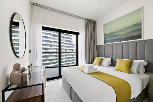 1 dormitorio con cama grande y ventana grande en StoneTree - Modern 1BR in Binghatti Creek, en Dubái