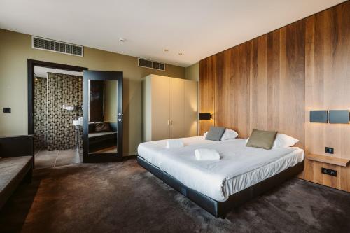 サン・ニコラにあるSerwir Hotelのベッドルーム(大型ベッド1台付)、バスルームが備わります。