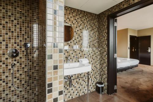 een badkamer met een wastafel en een douche bij Serwir Hotel in Sint-Niklaas