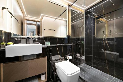 a bathroom with a toilet and a sink and a shower at StoneTree - Modern 1BR in Binghatti Creek in Dubai
