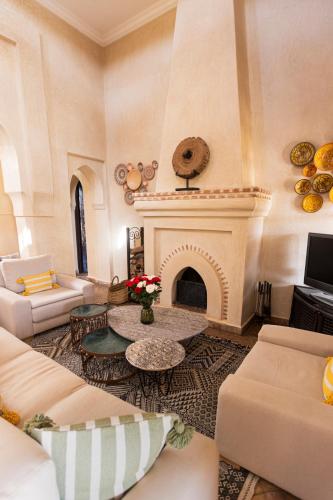 a living room with a couch and a fireplace at Villa Serena Marrakech - Maison d'hôtes in Marrakech