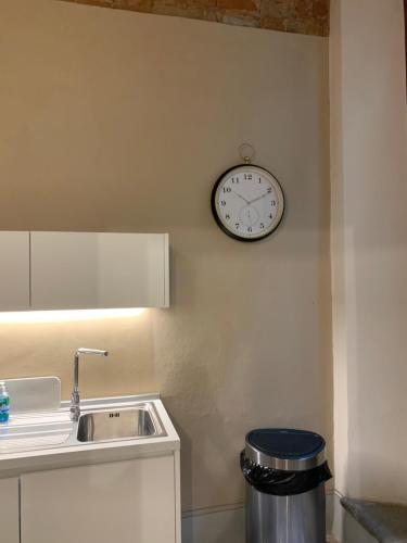 a kitchen with a clock on the wall and a sink at La casa della Francesca * * * * * in Florence
