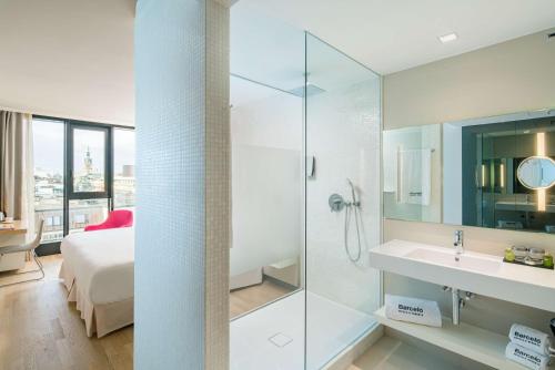 a bathroom with a shower and a bed and a sink at Barceló Hamburg in Hamburg