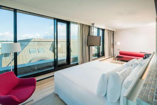 a bedroom with a large bed and a large window at Barceló Hamburg in Hamburg