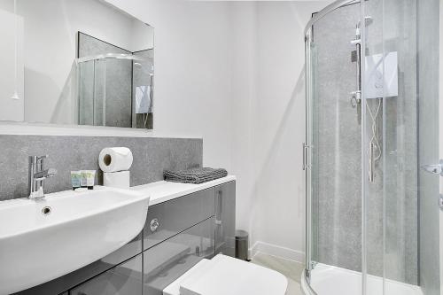 a white bathroom with a sink and a shower at Modern Apartments in the Heart of Middlesbrough 2 in Middlesbrough