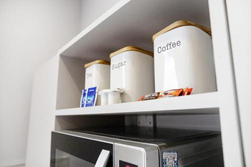 a microwave oven with boxes on top of it at Small Studio Apartment on Linthorpe Road, Middlesbrough with Free WiFi, Free Private Parking, Smart TV & Self-Catering Kitchen in Middlesbrough