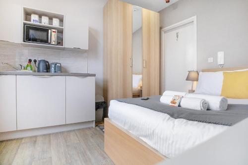 a bedroom with a large bed and a kitchen at Small Studio Apartment on Linthorpe Road, Middlesbrough with Free WiFi, Free Private Parking, Smart TV & Self-Catering Kitchen in Middlesbrough