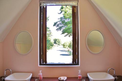 a bathroom with two sinks and two mirrors at CHANTILLY in Ceres