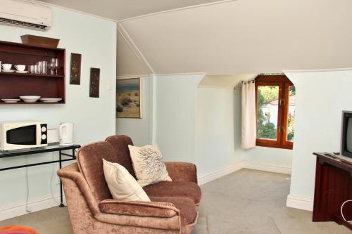 a living room with a chair and a microwave at CHANTILLY in Ceres