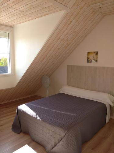 une chambre avec un grand lit dans un grenier dans l'établissement La Gilleterie, à Varades