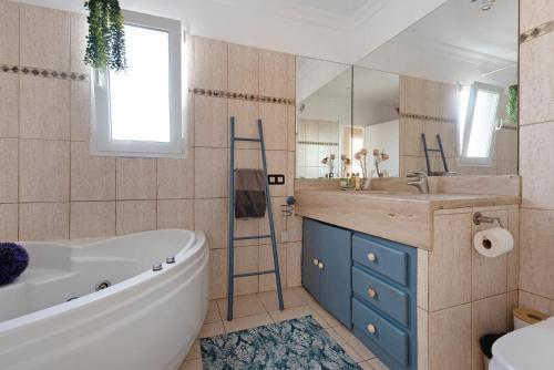 ein Badezimmer mit einer Badewanne, einem Waschbecken und einem Spiegel in der Unterkunft Villa Horizonte in Santa Úrsula