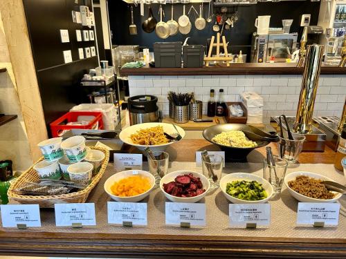 a buffet with bowls of food on a counter at Henn na Hotel Kyoto Hachijoguchi in Kyoto