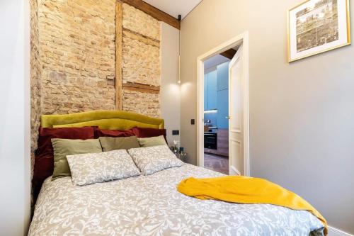a bedroom with a bed and a brick wall at Charming apartment next to the Church of St Anne by Reside Baltic in Vilnius