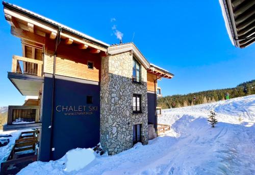 a building in the snow with snow around it at ChaletSKI Jasná, SKI-IN & SKI-OUT in Demanovska Dolina