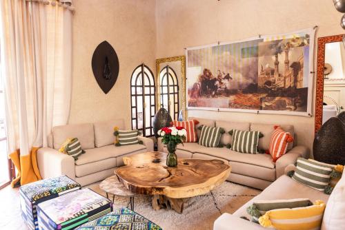 a living room with couches and a wooden table at Villa Serena Marrakech - Maison d'hôtes in Marrakech