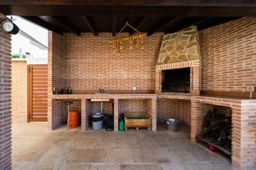 una cocina al aire libre con una pared de ladrillo y un fregadero en Casa Rural Alvaro, en Albares