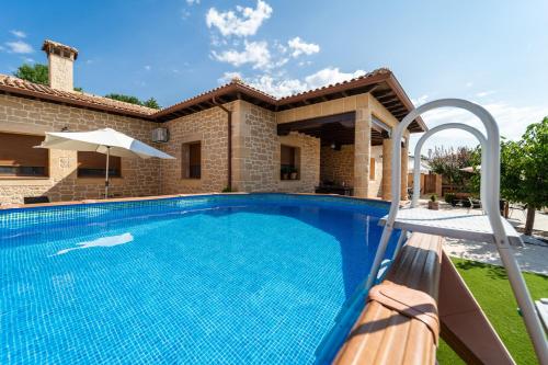 a swimming pool in front of a house at Casa Rural Alvaro in Albares