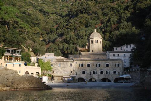 a large building with a clock tower next to the water at I Tre Merli Locanda in Camogli