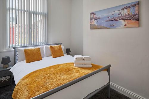 una camera da letto con un grande letto bianco con cuscini arancioni di Host & Stay - Diamond One a Saltburn-by-the-Sea