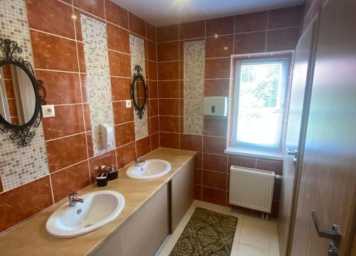 La salle de bains est pourvue de 2 lavabos, d'un miroir et d'une fenêtre. dans l'établissement Vila Forest Resort, 