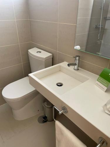 um banheiro com vaso sanitário branco e pia em INATEL Oeiras em Oeiras