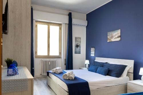ein blaues Schlafzimmer mit einem Bett und einem Fenster in der Unterkunft Riva Serena in Lido di Ostia