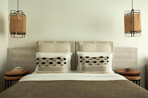 a bedroom with a bed with three pillows at Mare Ayia Napa in Ayia Napa