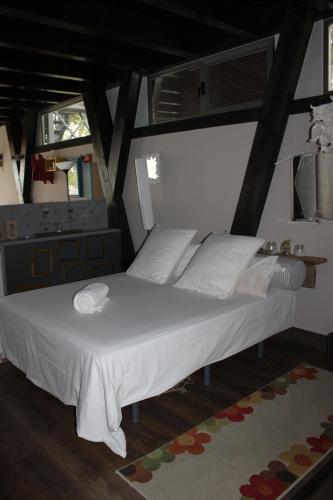 a bedroom with a large bed with white sheets at Bungalows de La Casona del Lago in Serranillos Playa
