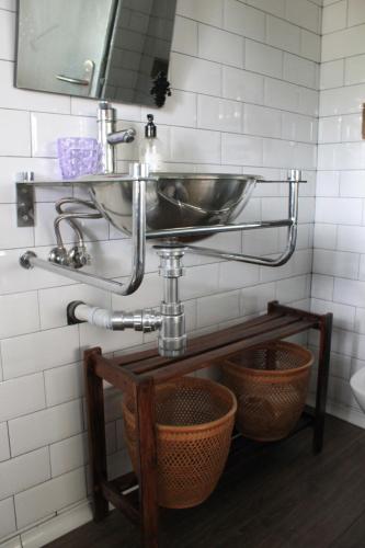a bathroom with a sink and a basket at Bungalows de La Casona del Lago in Serranillos Playa