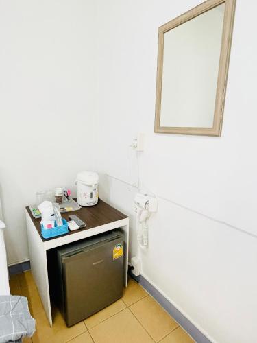 a bathroom with a small refrigerator and a mirror at Dragon XIV in Bangkok