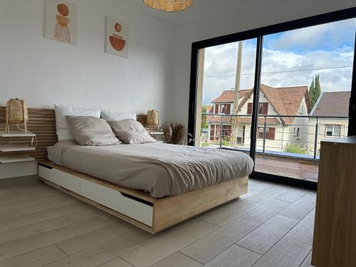 1 dormitorio con cama y ventana grande en RESIDENCE FAIDHERBE avec terrasse et jardin, en Champigny-sur-Marne