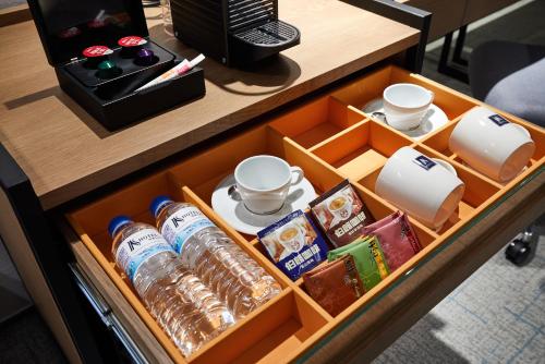 a drawer in a desk with drinks and cups at K Hotel Taipei Nanjing in Taipei