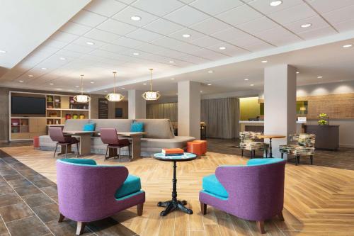 a lobby with purple and blue chairs and a table at Home2 Suites By Hilton Milwaukee West in West Allis