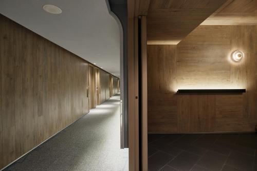 a hallway in a building with wooden walls at K Hotel Taipei Nanjing in Taipei