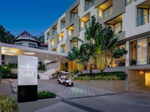 a car parked in front of a building at Andaman Beach Hotel Phuket - Handwritten Collection in Patong Beach