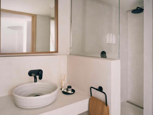 een badkamer met een grote witte wastafel op een aanrecht bij Mondrian Ibiza in Cala Llonga