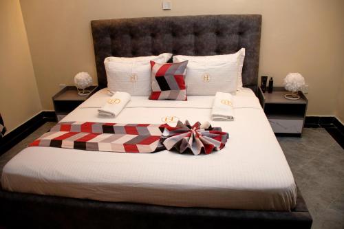 ein Schlafzimmer mit einem Bett mit weißen Laken und Schleifen in der Unterkunft Thehaven254 in Nakuru