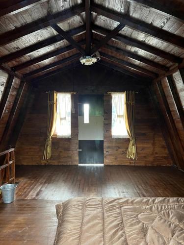 a bedroom with a bed in a room with windows at Ulina Villa Lokan A Berastagi in Berastagi