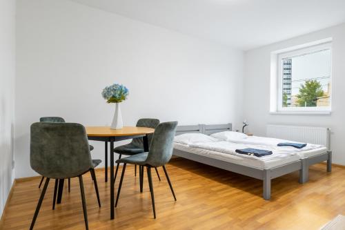 - une chambre avec un lit, une table et des chaises dans l'établissement Apartmány Borská Plzeň, à Plzeň