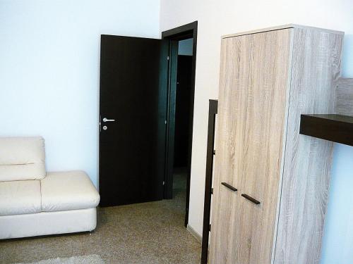 - une porte menant à une chambre avec un canapé et une chaise dans l'établissement Simona‘s apartment Mackerel, à Mamaia Nord – Năvodari