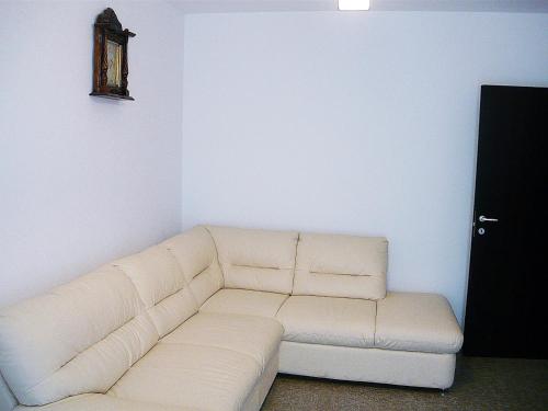 - un canapé blanc dans le salon avec une horloge murale dans l'établissement Simona‘s apartment Mackerel, à Mamaia Nord – Năvodari